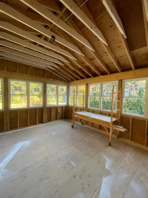 An empty room with a wooden table and scaffolding in it.