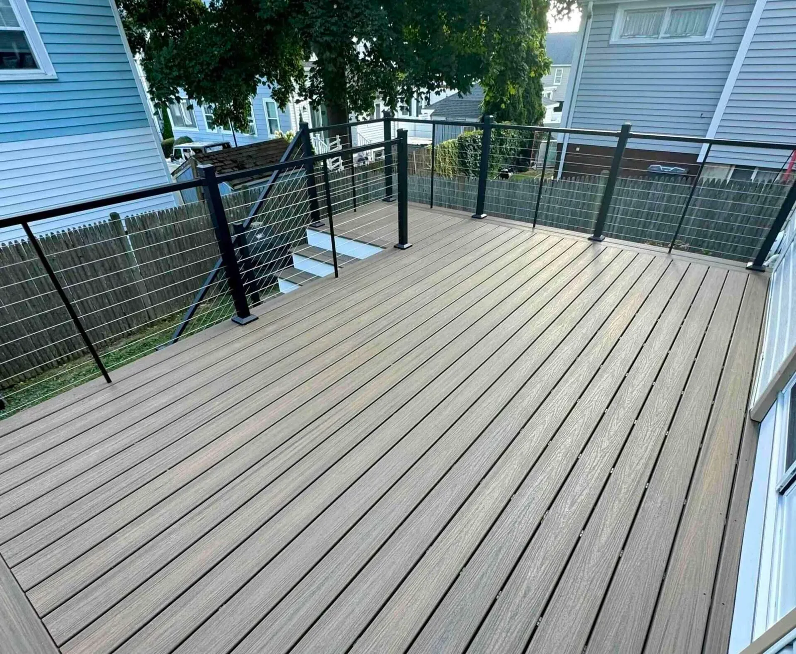 Deck repair with cable railing on the big house with wooden fence in worcester ma