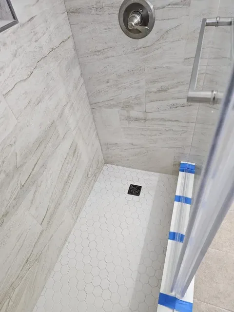 a shower stall with a sliding glass door and a shower head .