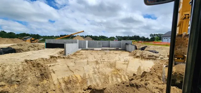 A construction site with a lot of dirt and a bulldozer in the background.