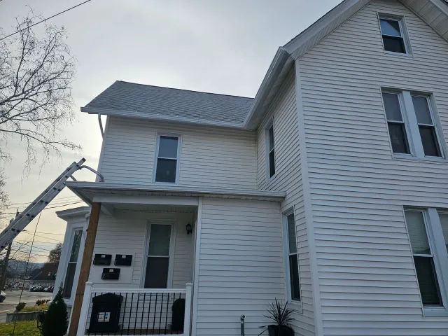 A close up of a white gutter on the side of a house.