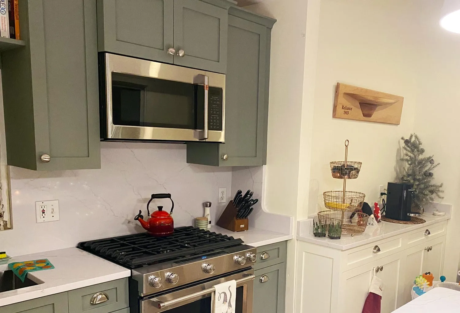 Custom sage-green kitchen cabinetry with built-ins