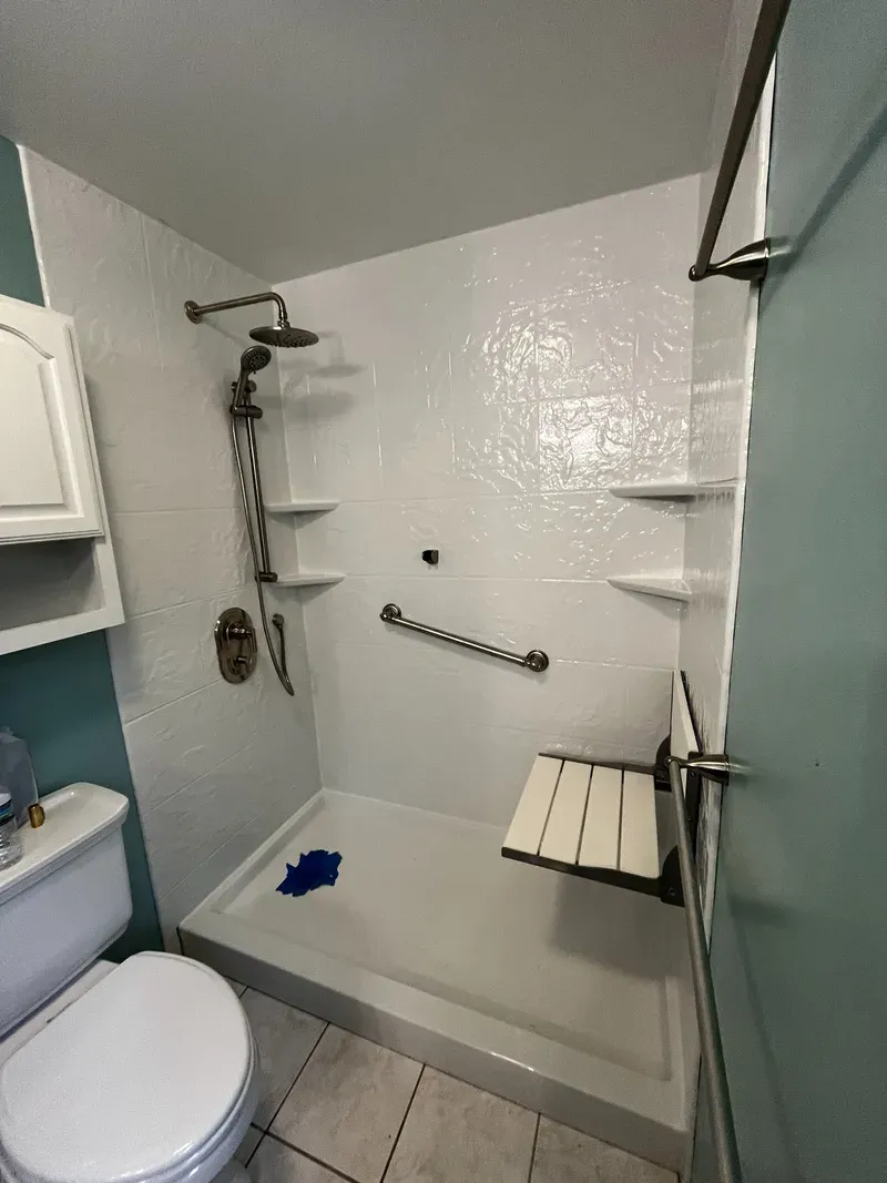 Finished acrylic shower with folding seat down, grab bar, sliding bar and rain head