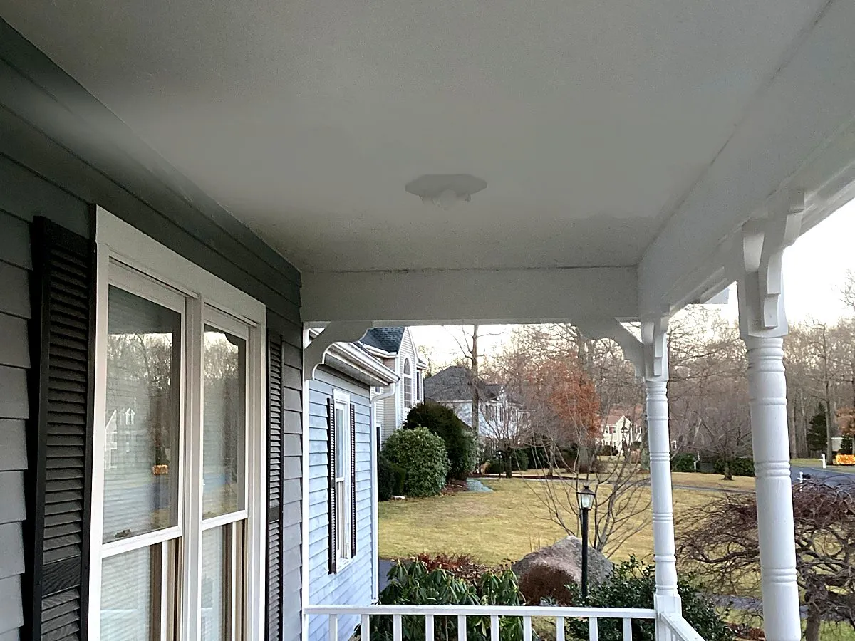Finished smooth painted porch ceiling with light fixture installed