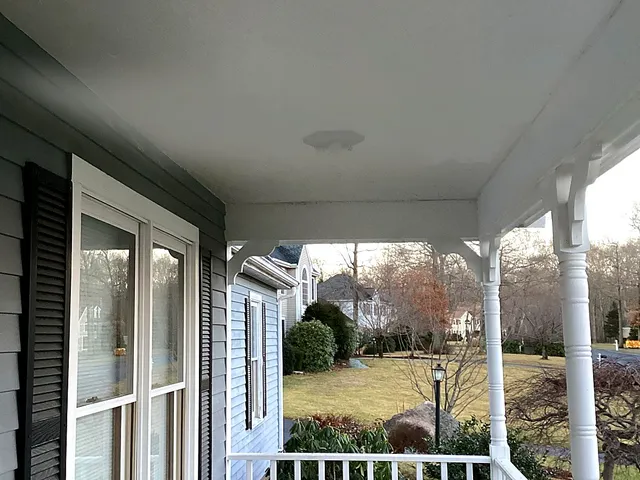 Finished smooth painted porch ceiling with light fixture installed