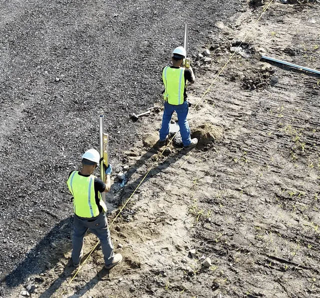 Worker installing a fence post, Rhode Island.