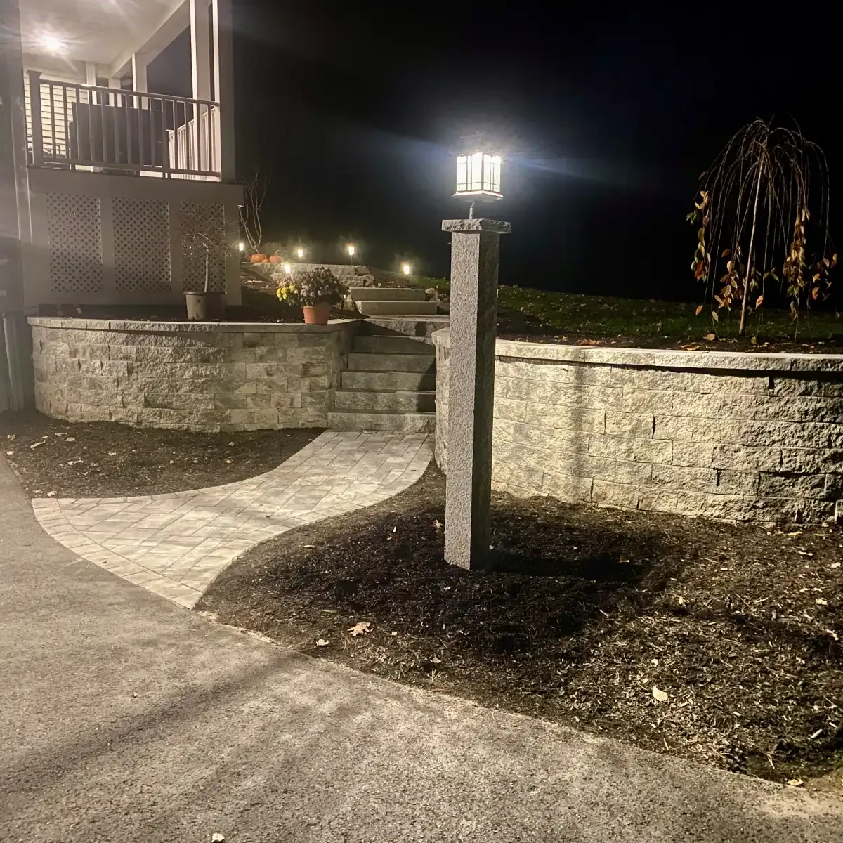 SRW retaining wall retaining the front yard with a walkway and granite steps running from the driveway to the front door