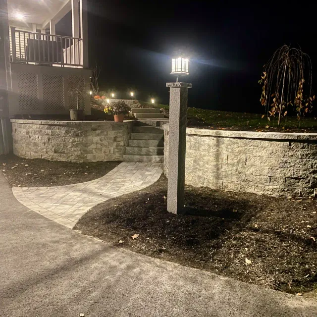 SRW retaining wall retaining the front yard with a walkway and granite steps running from the driveway to the front door