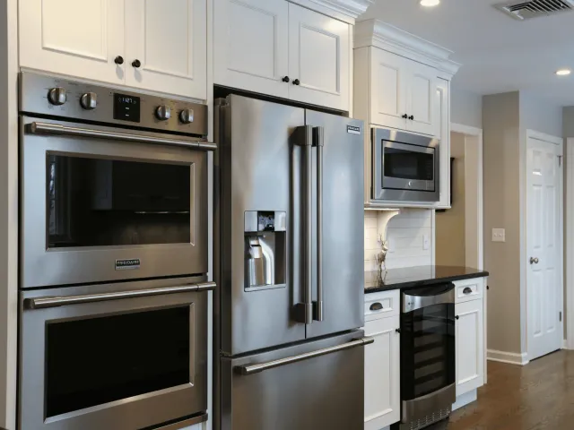 Stainless steel refrigerator and built-in oven in a modern kitchen.