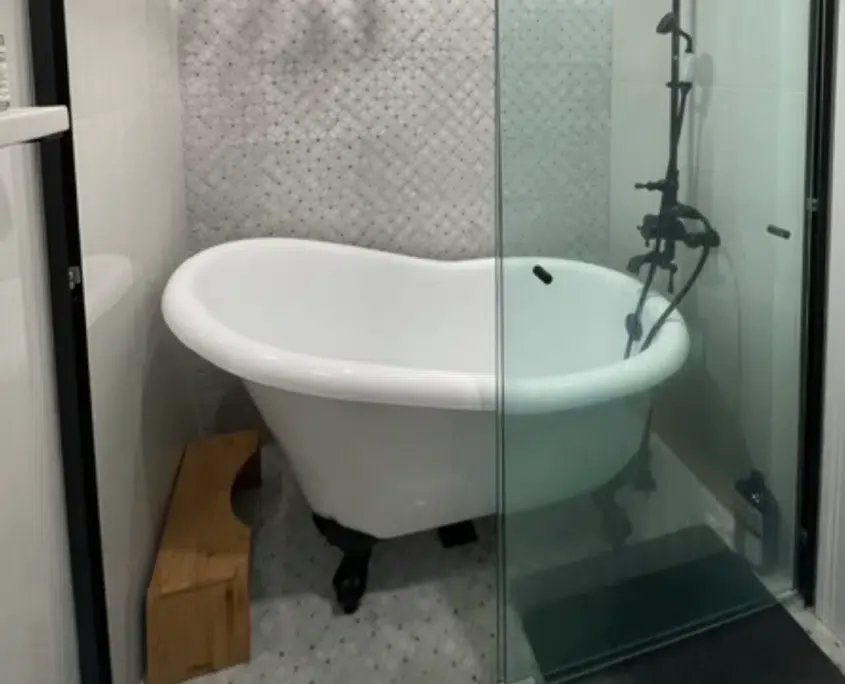 Tub-in-shower wetroom, also known as a shub. Features a freestanding bathtub inside of an open shower.