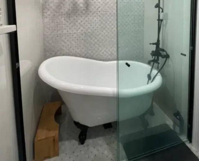 Tub-in-shower wetroom, also known as a shub. Features a freestanding bathtub inside of an open shower.