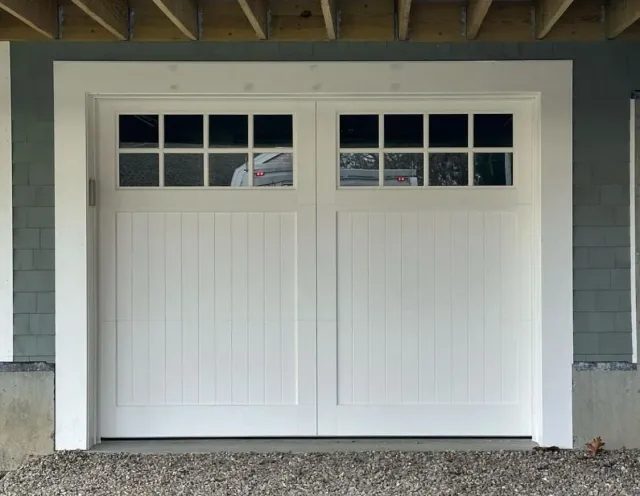 A white garage door with a reflection of a car in it