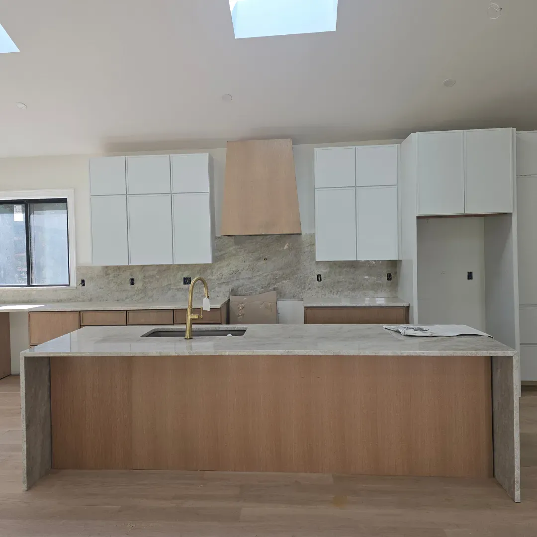 Modern kitchen island with quartz waterfall and natural wood cabinets by Link Services Pro in Worcester, MA