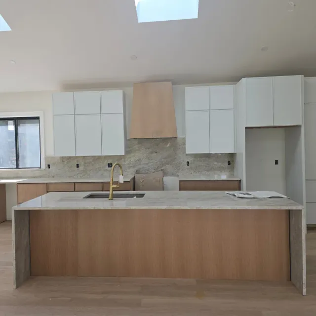 Modern kitchen island with quartz waterfall and natural wood cabinets by Link Services Pro in Worcester, MA