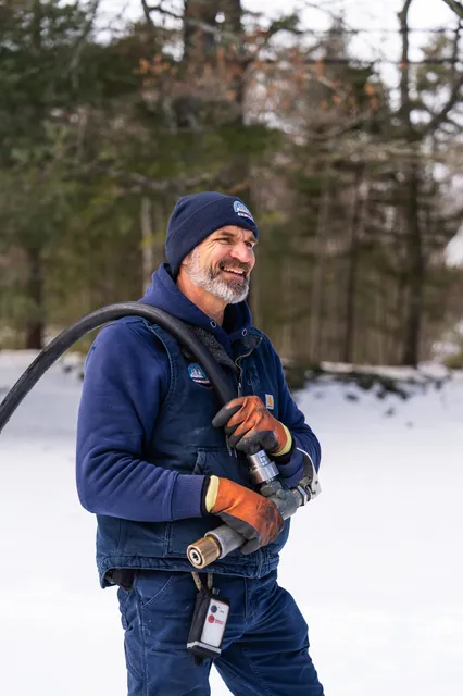 Propane delivery driver Jason holding a fuel hose during a professional residential service call.