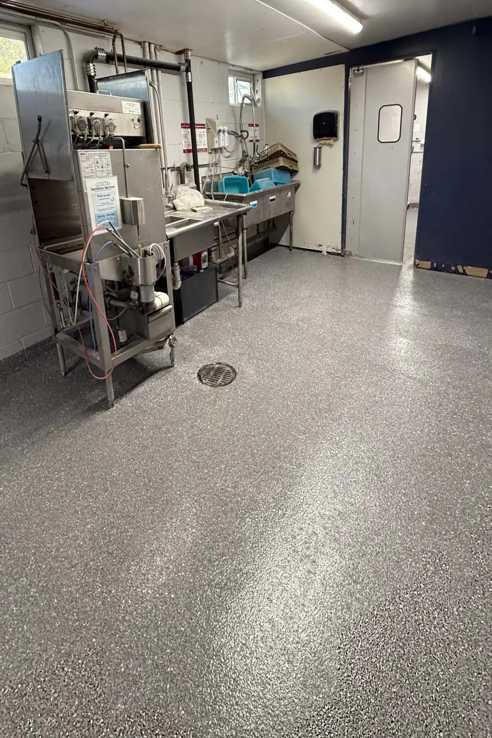 a commercial setting with an epoxy floor with grey white and black flake color