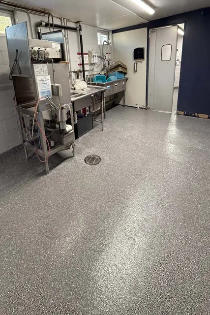 a commercial setting with an epoxy floor with grey white and black flake color