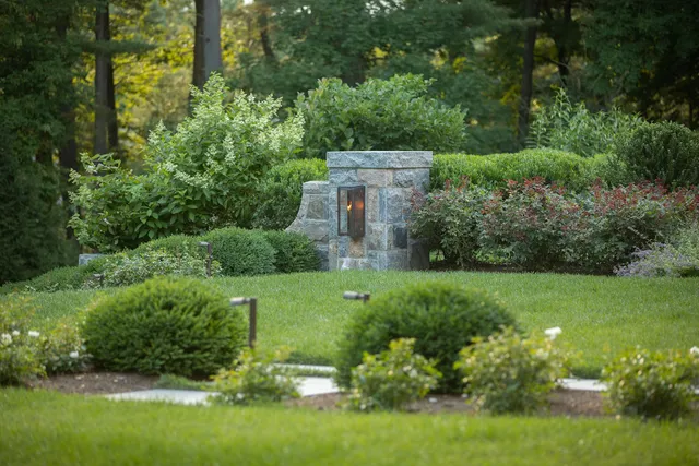 Stone lantern pier and clipped hedges in a woodland garden