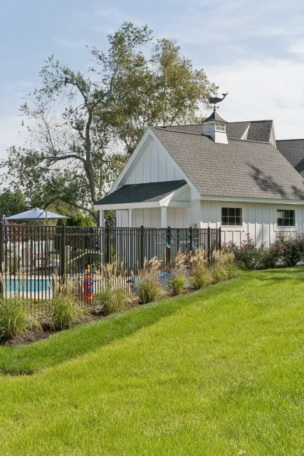 Hand-drawn landscape design with paths, flowerbeds, trees, and a structure. Color-coded details on a white background.