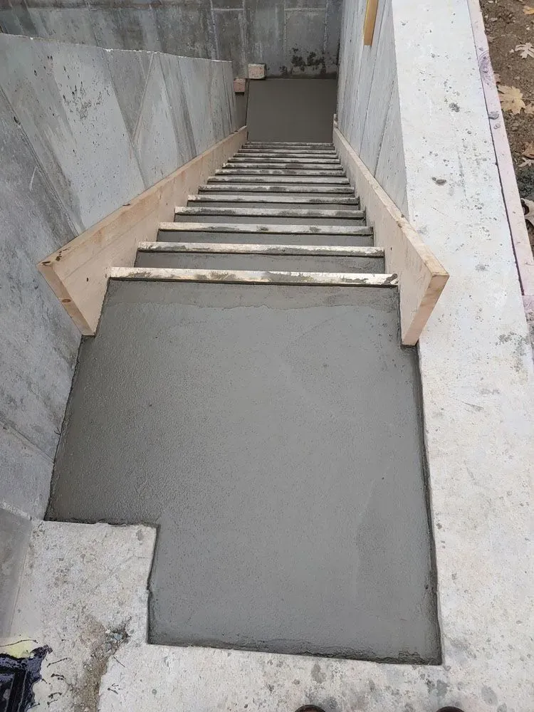 A concrete staircase is being built in a basement.