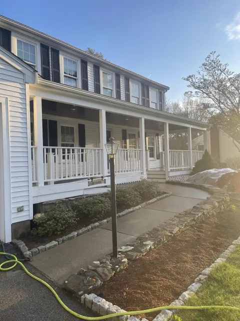 Freshly cleaned white colonial home with a stone walkway in Foxborough, MA