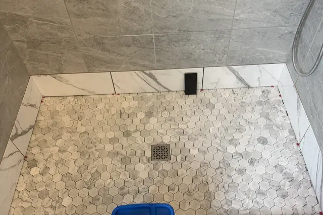 New marble hexagon mosaic shower floor with square drain and quartz curb — shower tile installation by Dmtilellc in Newington, CT