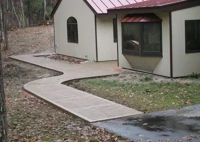 A walkway leading to a house with a pink roof
