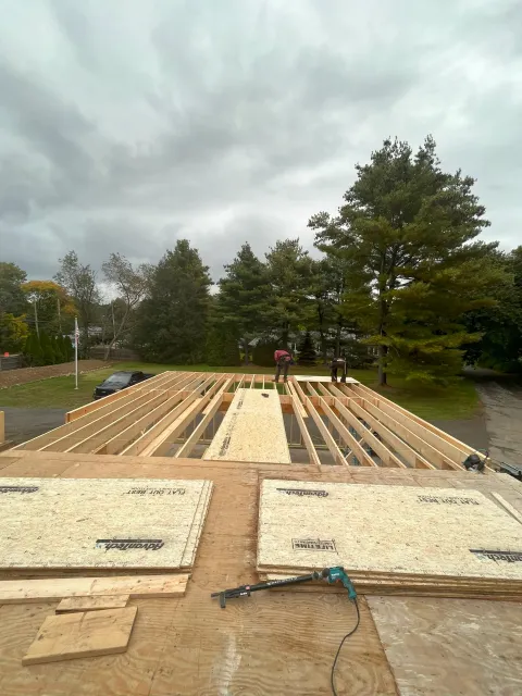 Construction workers installing AdvanTech OSB subfloor panels on a new residential floor framing system.