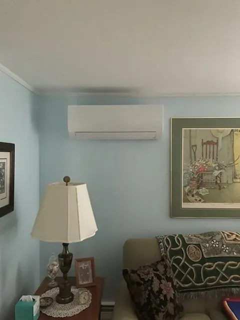 A living room with a lamp and a picture on the wall