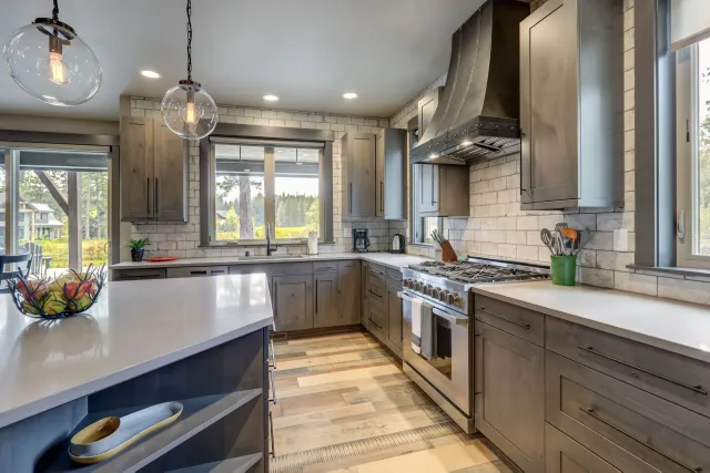 A kitchen with stainless steel appliances and gray cabinets.