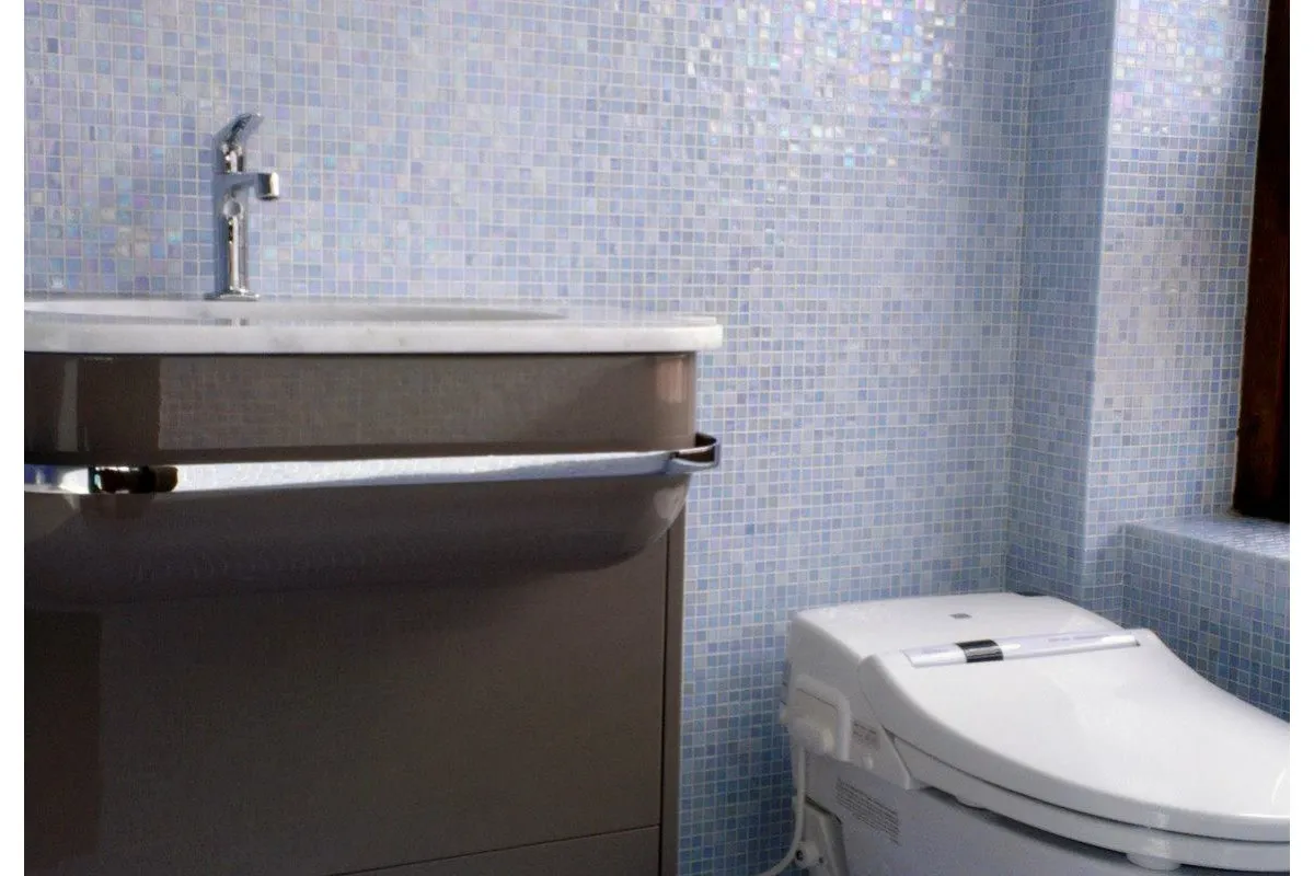 Loon House — bathroom with iridescent glass mosaic tile walls, sleek vanity.