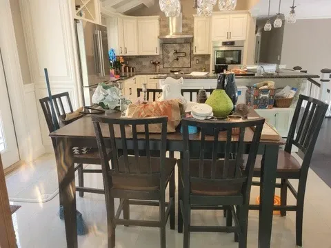 Kitchen and dining area with a wooden table and white cabinets
