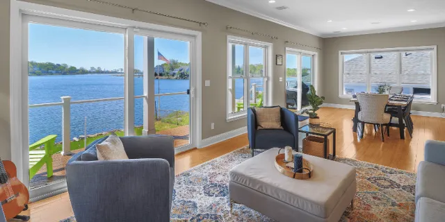 stunning open floor living room and dining room on the water by Raymond Design Builders