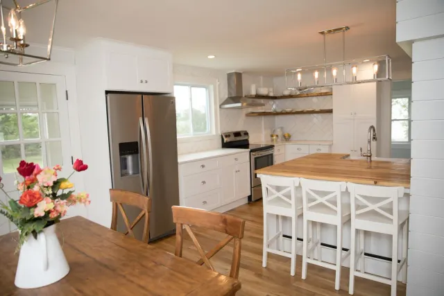 Modern kitchen with stainless steel appliances, white cabinets, and wooden accents.