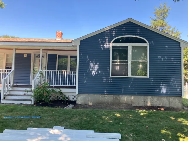New steel-blue vinyl siding installed on the rear gable