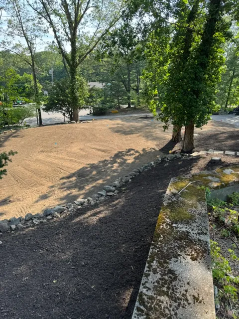 A regraded gravel driveway with a new stone border edge