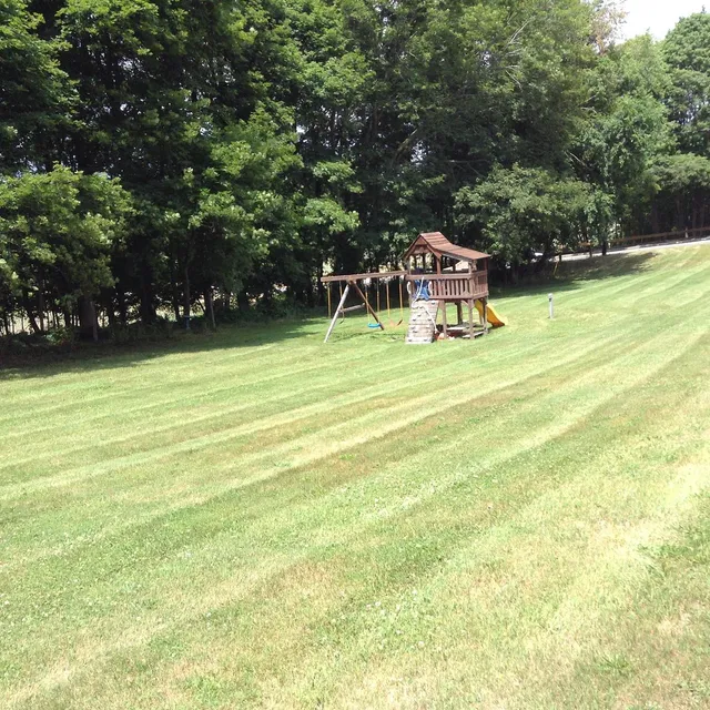Large striped back lawn with a play set