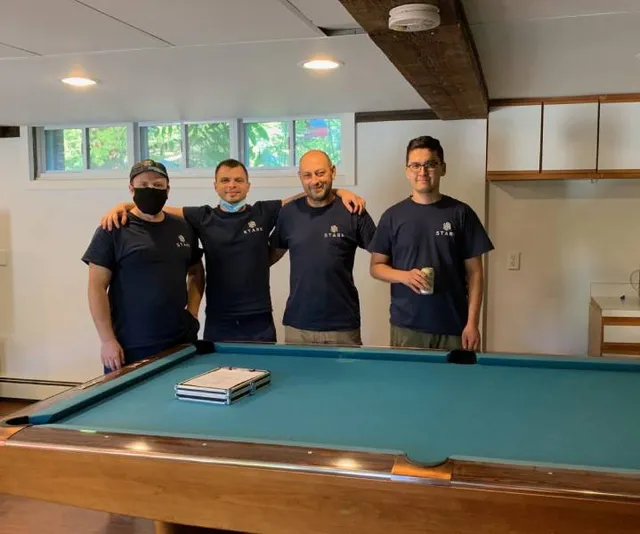 movers smiling next to a pool table