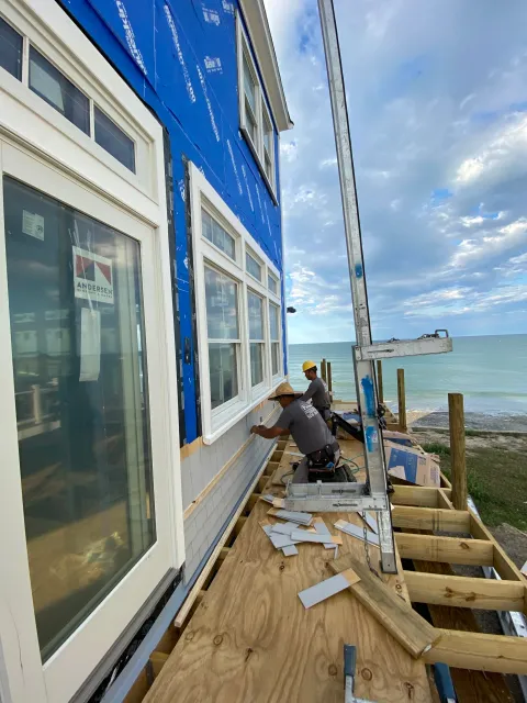 Skilled craftsmen from Fernandes Construction replace the windows on a historic waterfront home in Provincetown