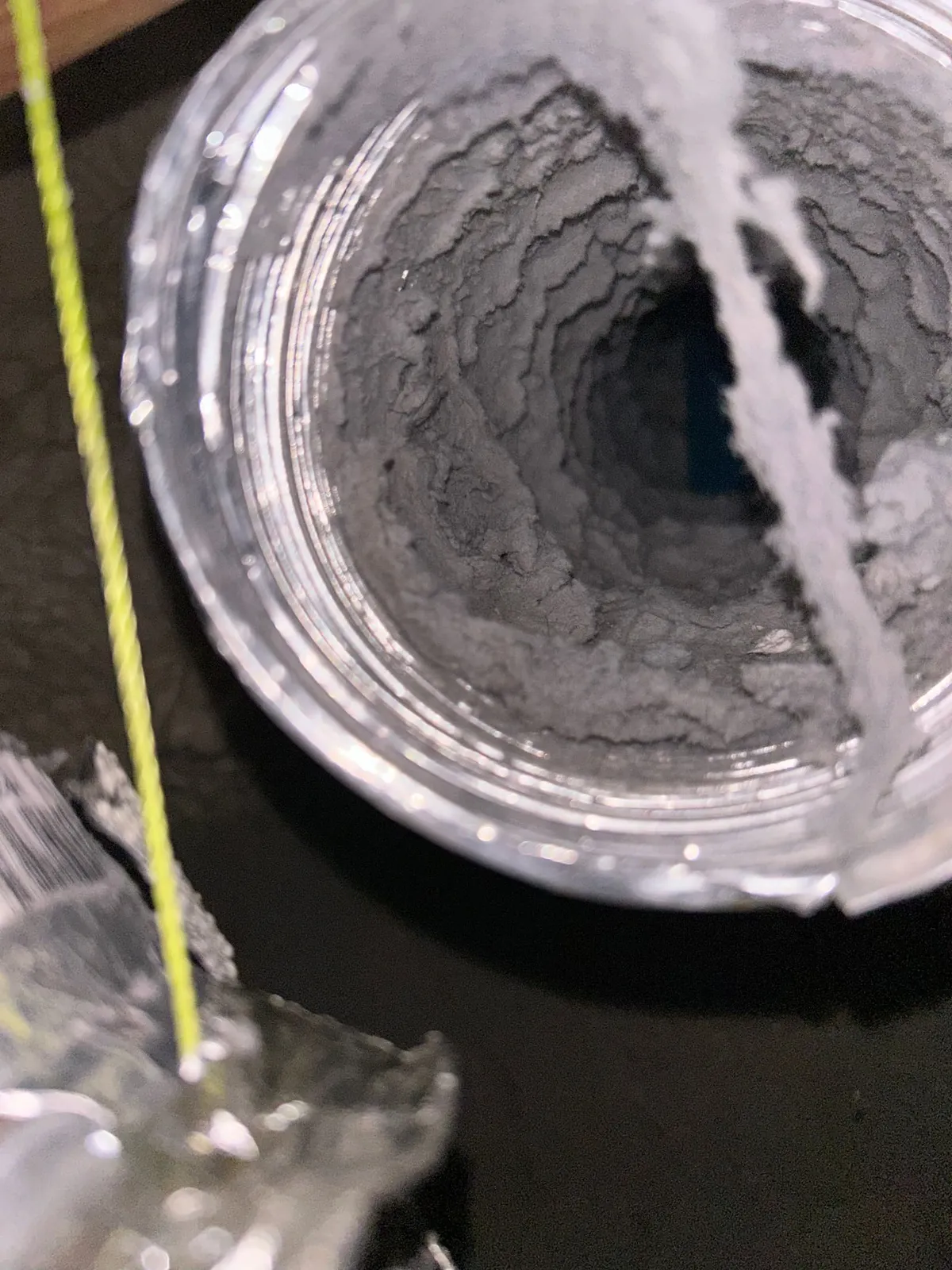 Lint buildup narrowing a flexible dryer duct to a fraction of its original diameter.