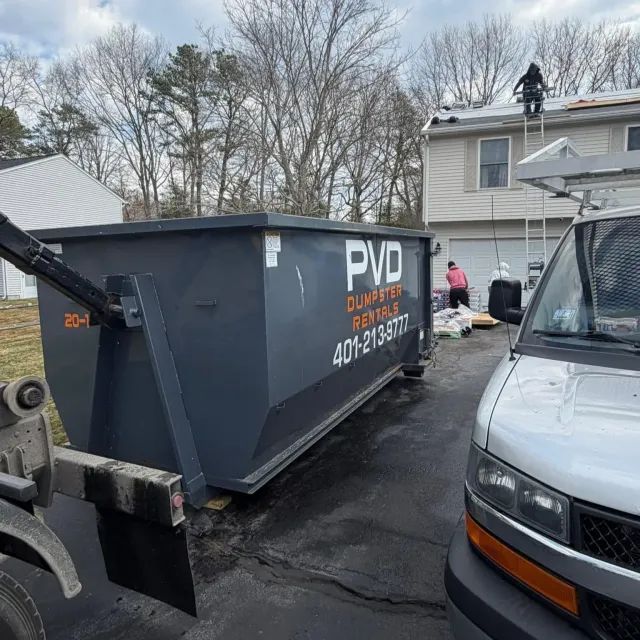 20 yard dumpster taking shingles from a tear-off on a roofing job in Rhode Island