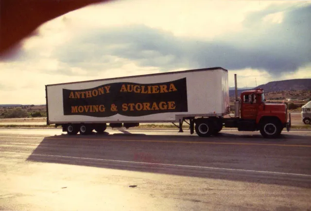 An anthony augliera moving and storage truck is parked on the side of the road