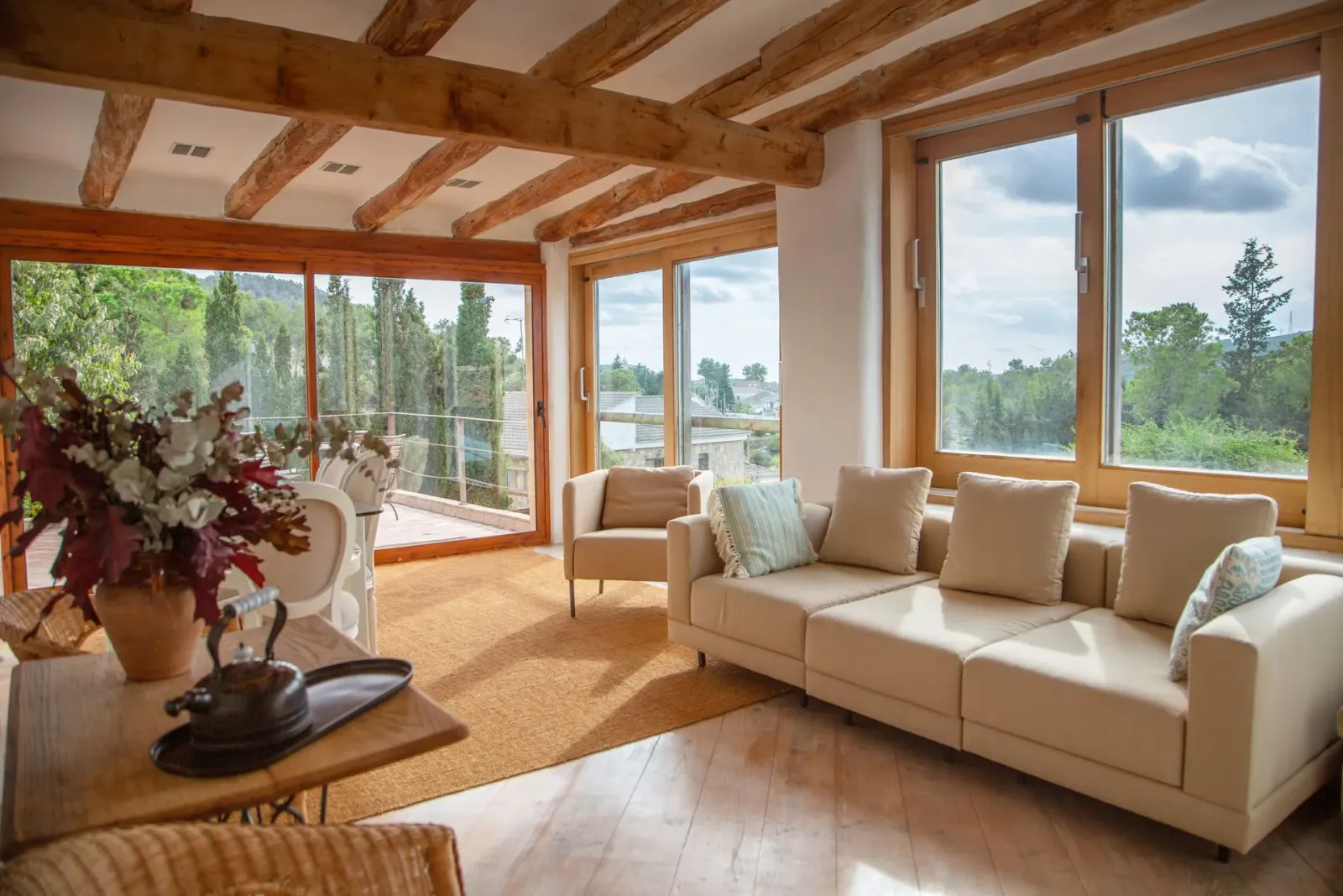 A living room with a couch , chairs , and lots of windows.