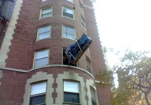 Road Warrior Moving & Storage – local moving company in Boston craning piano out window