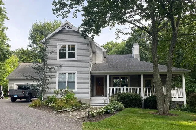 A house with a porch and a truck parked in front of it