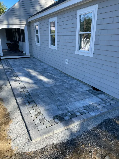 Scarborough, Maine cottage with a three-piece stone front patio hardscape built by The Englishmen Masonry