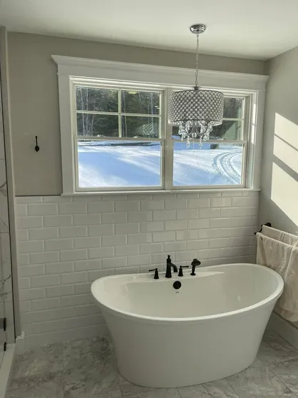 Bathroom project with freestanding tub and snowy view