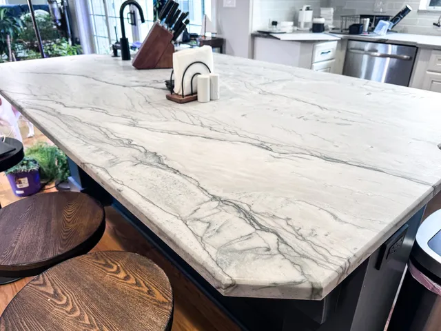 White marble kitchen island with veined surface and built-in sink in a modern kitchen