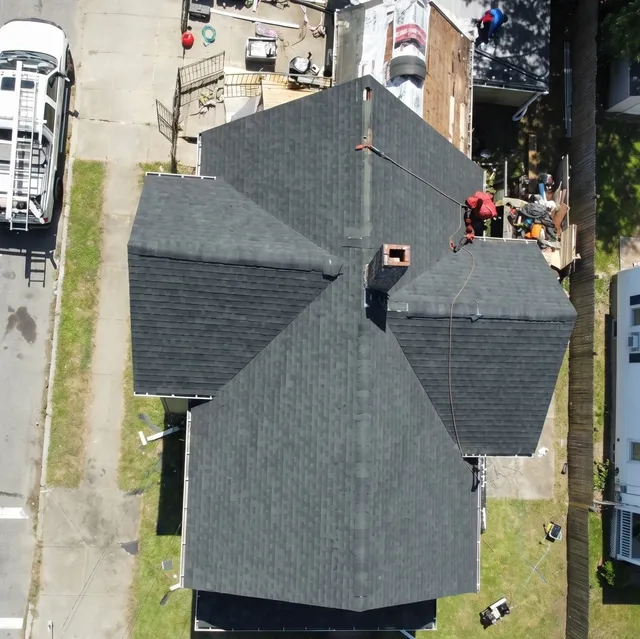 Aerial view of a newly installed dark architectural asphalt shingle roof on a Massachusetts home by Jennifer Construction