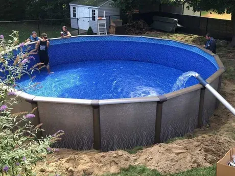 A large swimming pool is being built in a backyard.